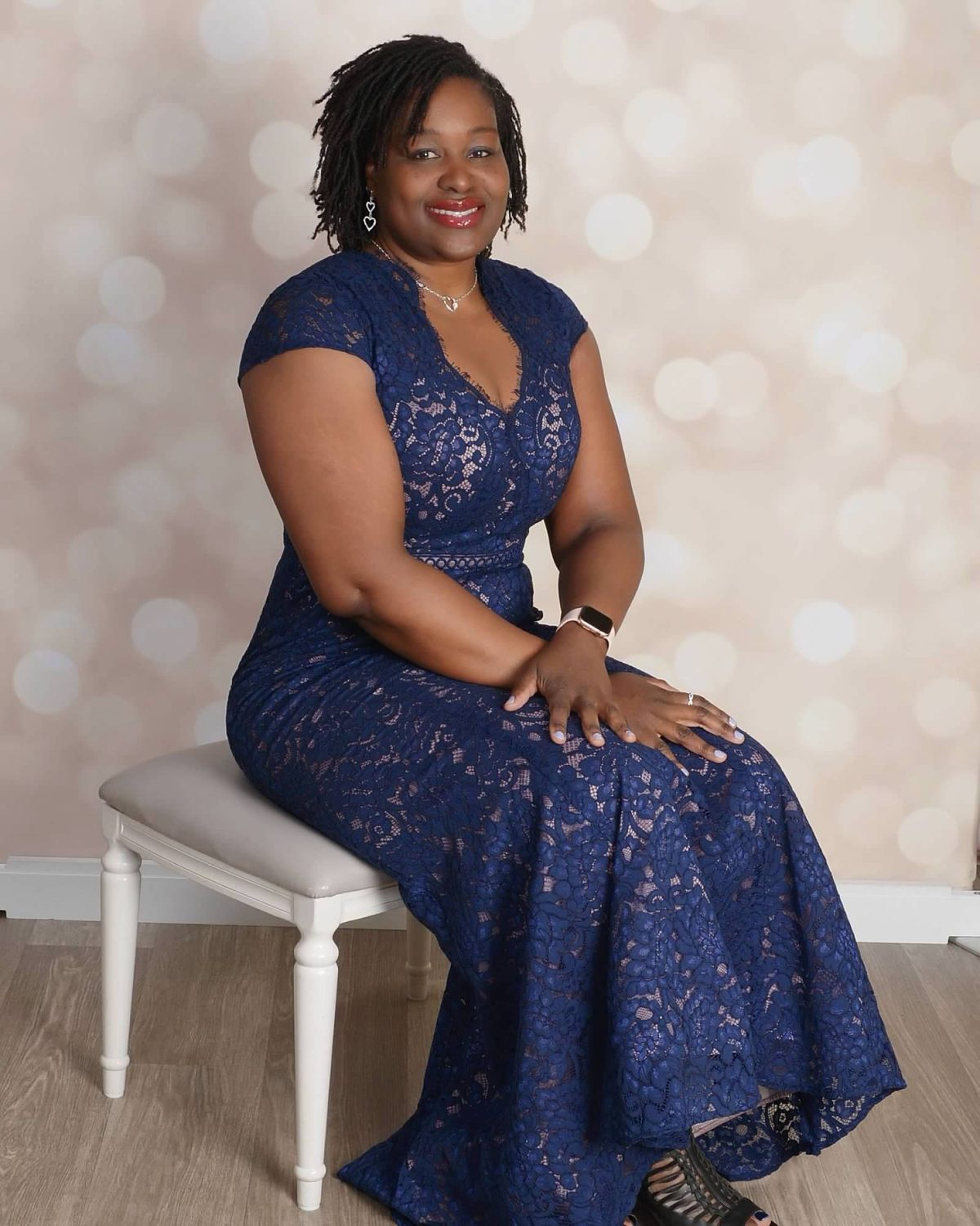 Rovna-Lyn T. Joseph seated in a navy lace gown
